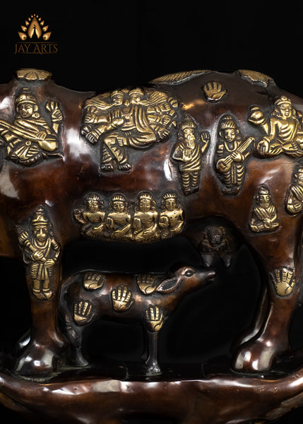 Brass Kamadhenu Cow Statue with Hindu Deity Engravings on Hand-Shaped Pedestal 17"