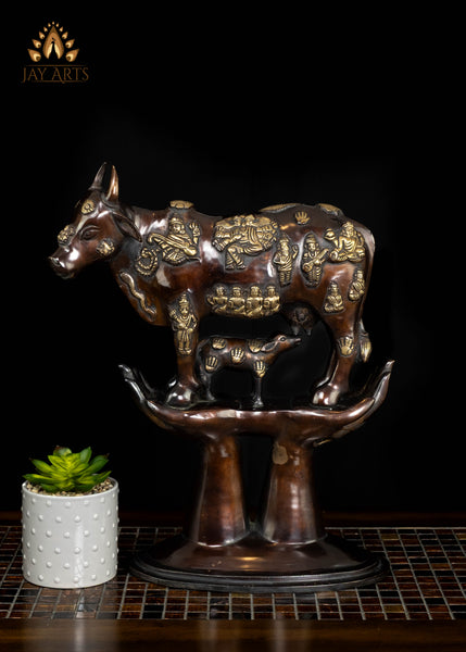 Brass Kamadhenu Cow Statue with Hindu Deity Engravings on Hand-Shaped Pedestal 17"