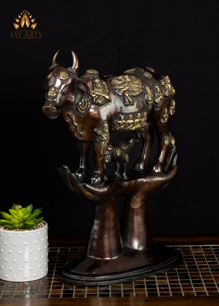 Brass Kamadhenu Cow Statue with Hindu Deity Engravings on Hand-Shaped Pedestal 17"