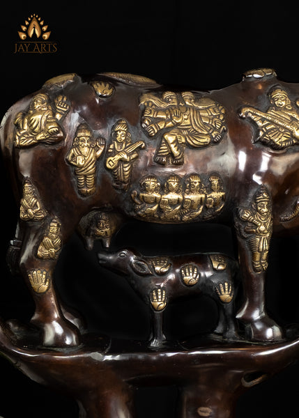 Brass Kamadhenu Cow Statue with Hindu Deity Engravings on Hand-Shaped Pedestal 17"