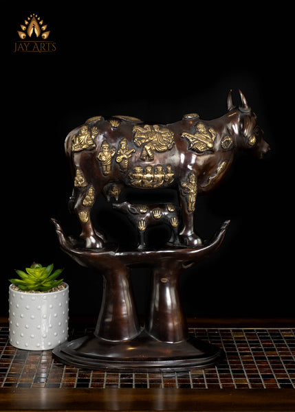Brass Kamadhenu Cow Statue with Hindu Deity Engravings on Hand-Shaped Pedestal 17"