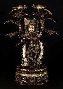Sri Krishna playing his flute under the canopy of a Kadamba tree