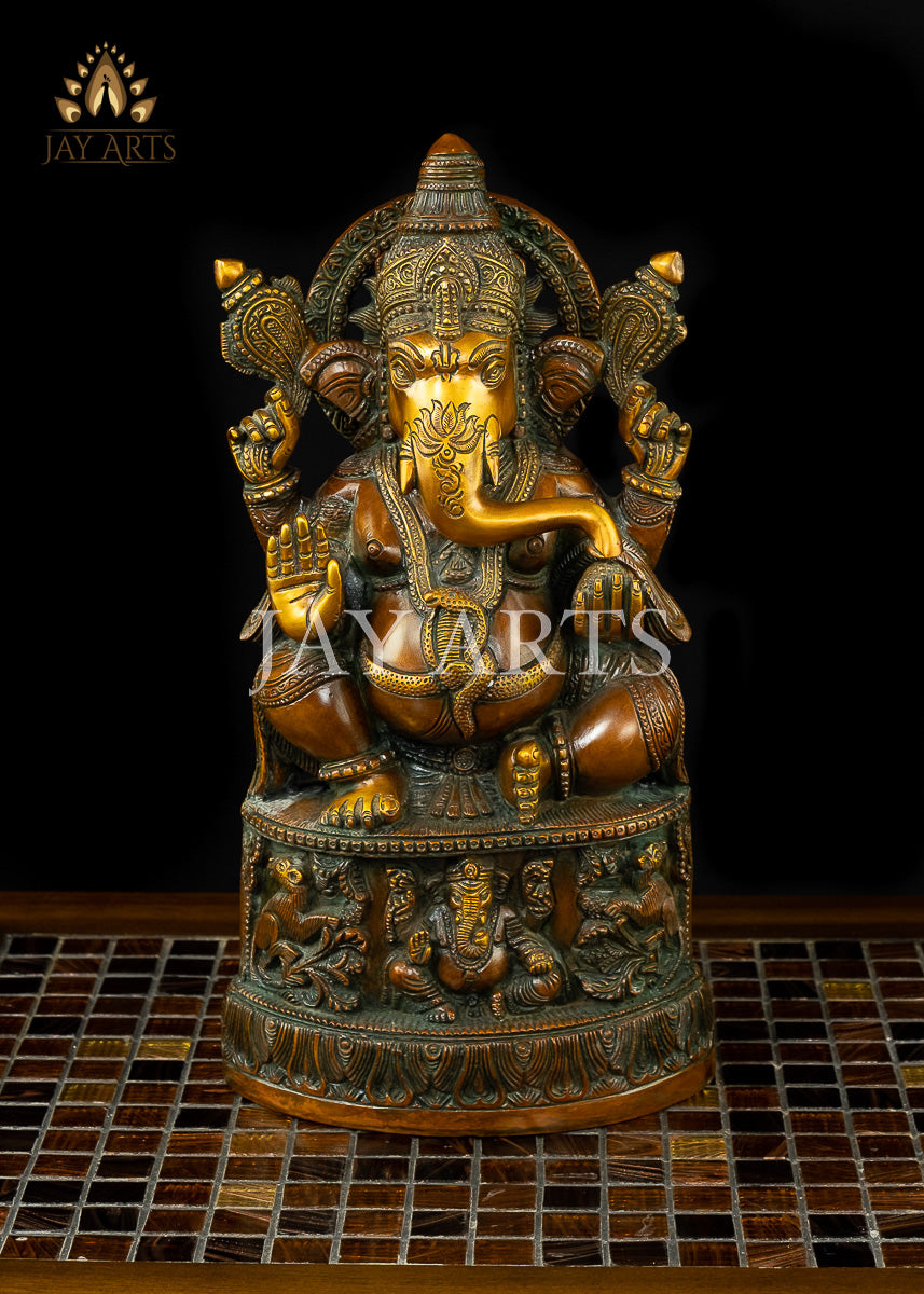13" Lord Ganesh with Surya Halo seated on a pedestal with figurines of Ganesh and Lakshmi